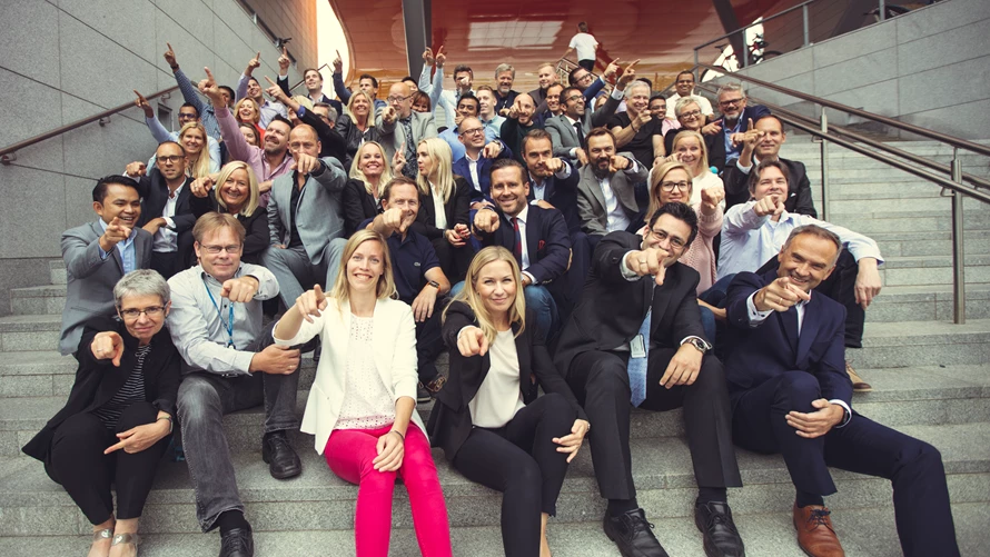 gruppebilde-med-ansatte-som-peker gruppebilde-med-ansatte-som-peker